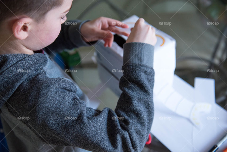 Young boy making a craft indoors