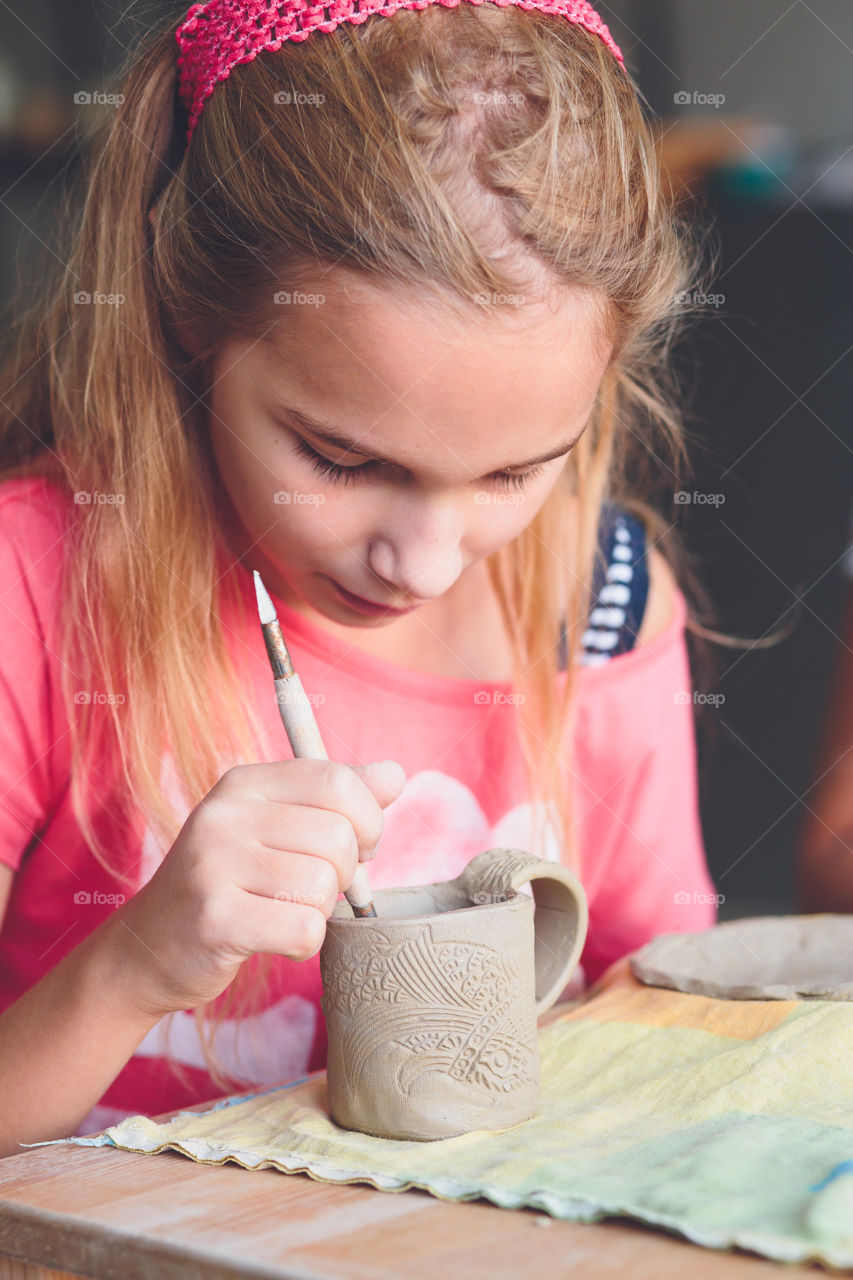 Girl making craft on clay