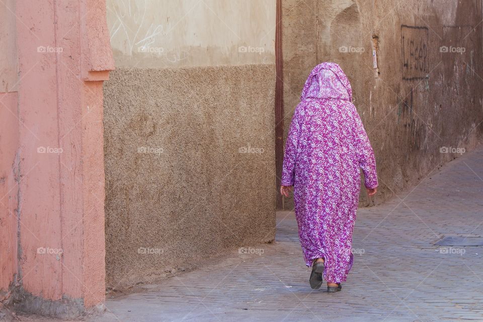 An unrecognizable Moroccan woman walking alone in the Medina District of Marrakesh, Morocco
