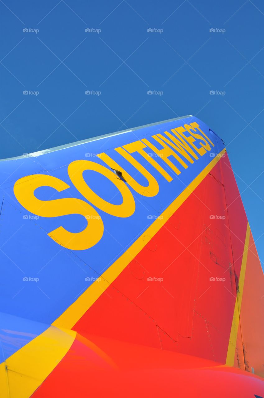 Southwest Airlines tail section rises into a bright blue sky.