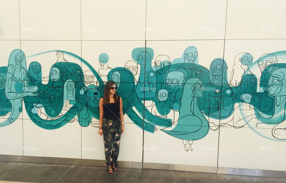 Stylish woman posing on background of wall graffiti