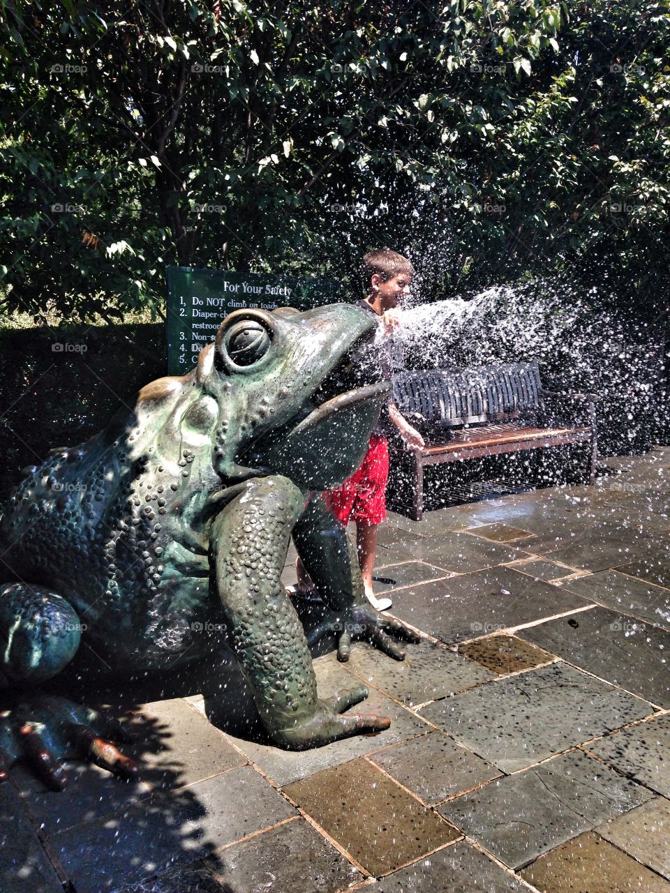 Time to cool off. Boy playing in water