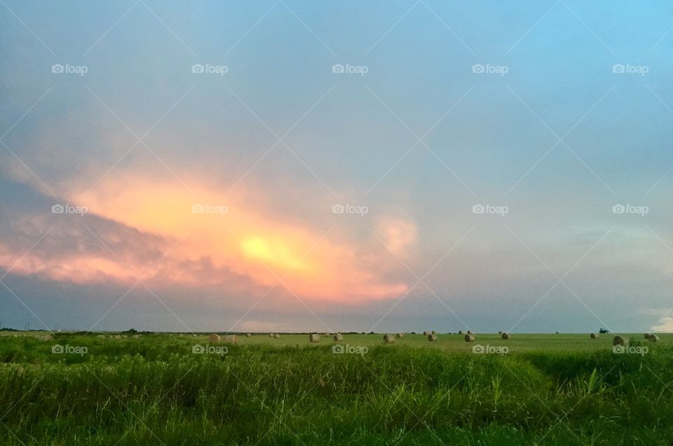 Storm clouds over a field at sunset. 