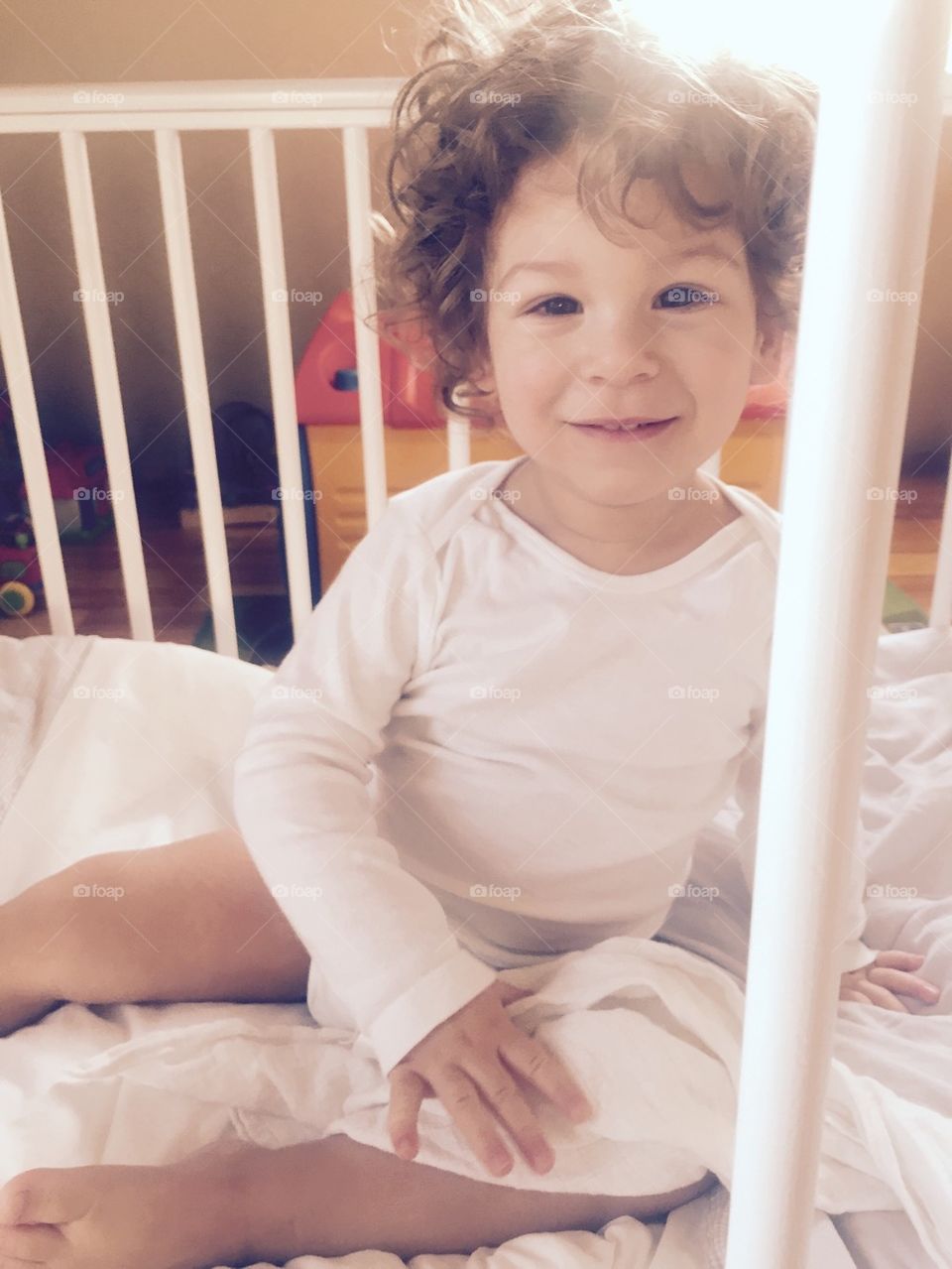 Chlopiec w łóżeczku uśmiecha się