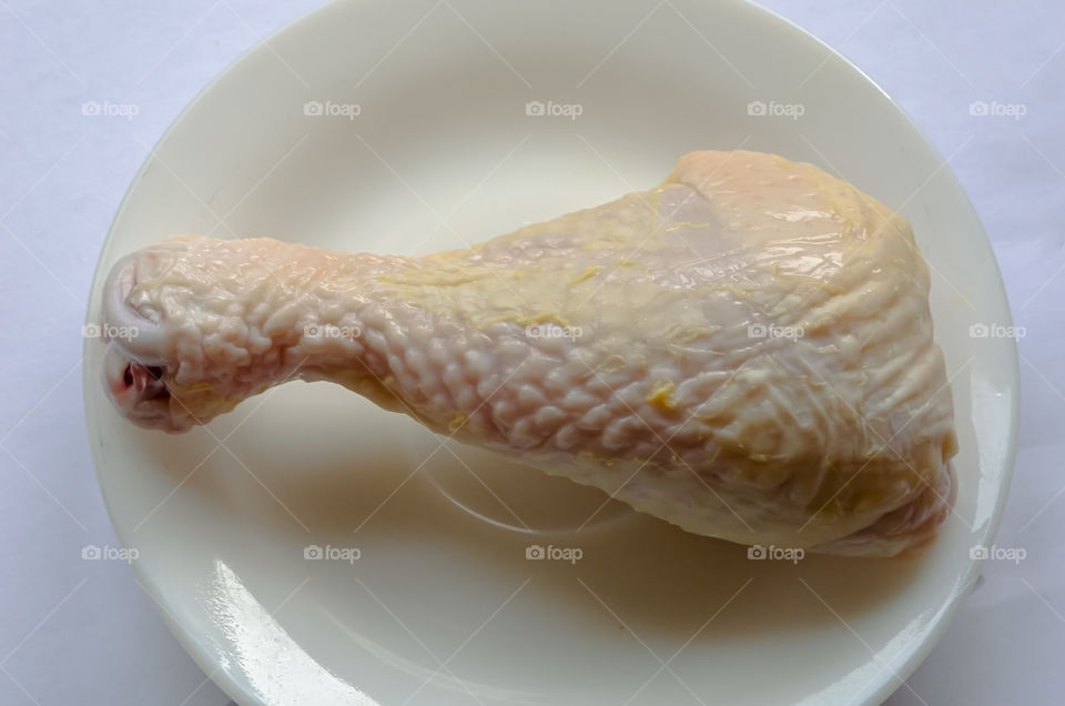 Uncooked Chicken Leg In White Plate