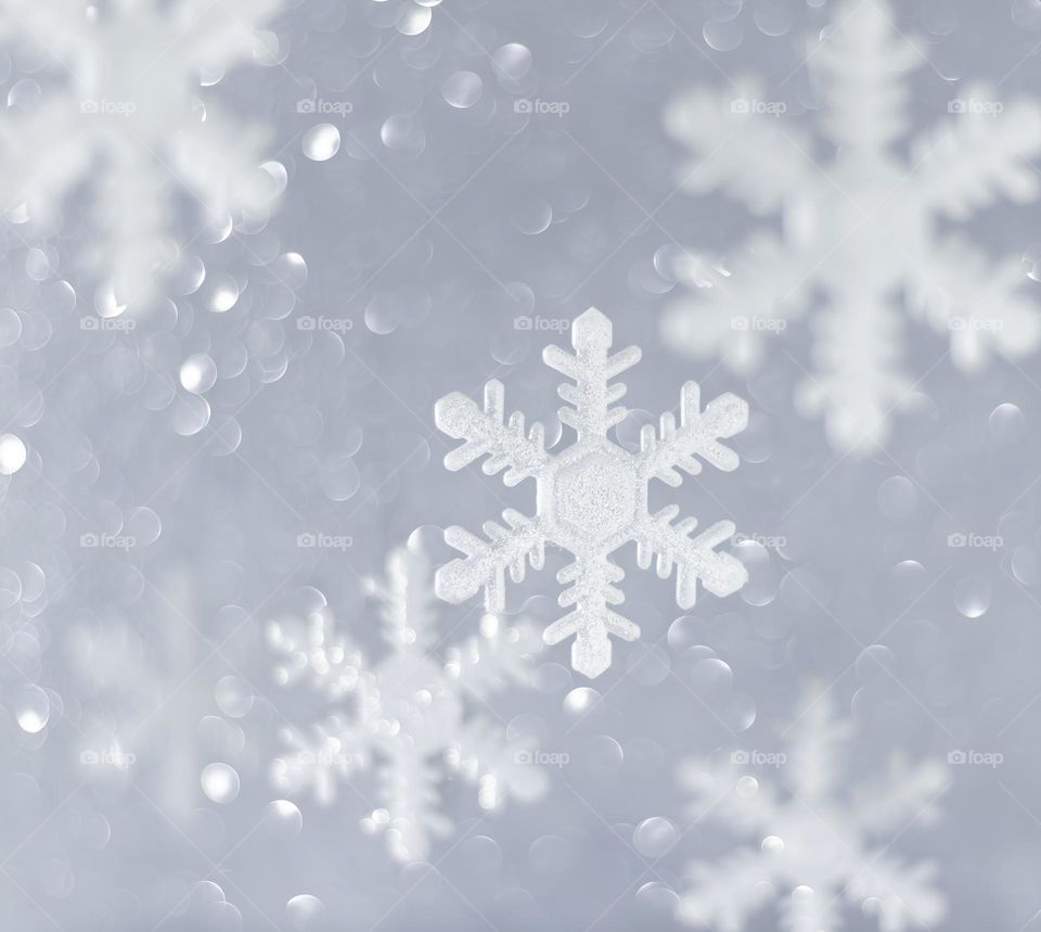 Snowflake Christmas ornaments against a glittery background 