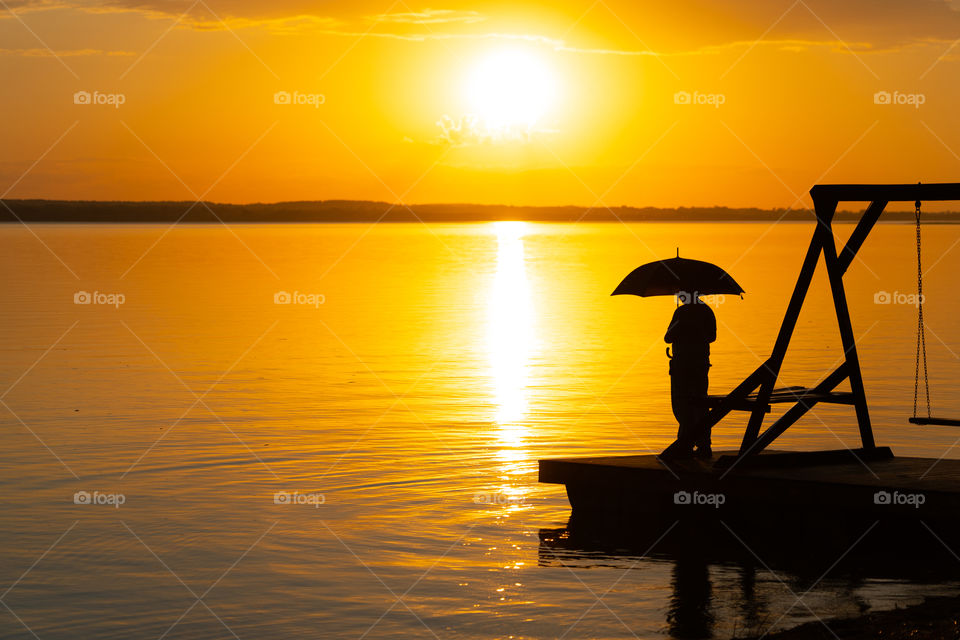 Warm summer evening. When is warm enough to watch the sunset on the lake.