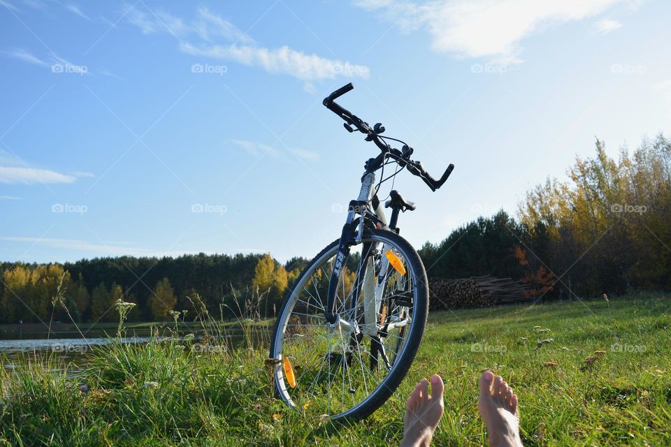 bike and female legs barefoot relaxing on a lake shore beautiful nature landscape