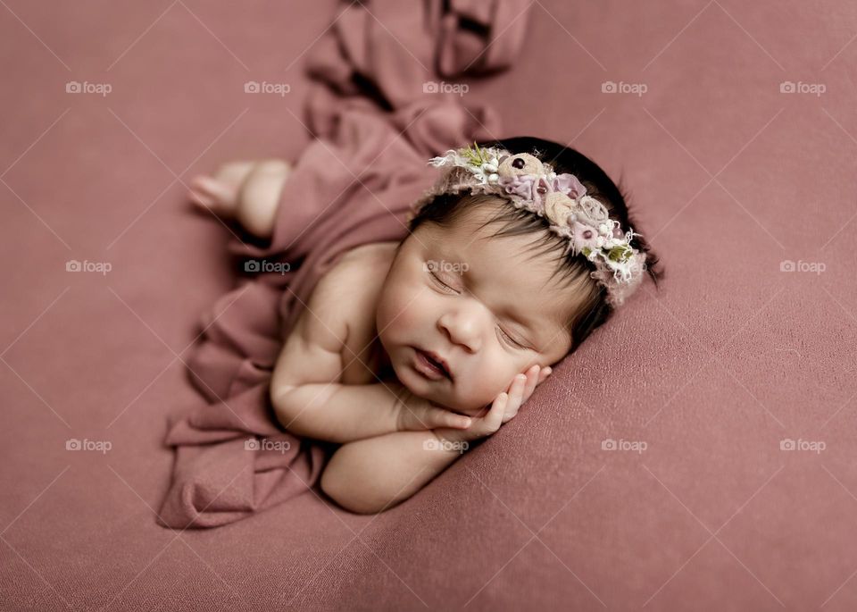 Newborn baby surrounded by pink, newborn baby sleeping quietly, newborn infant posed for photograph, tender moments with newborn baby 