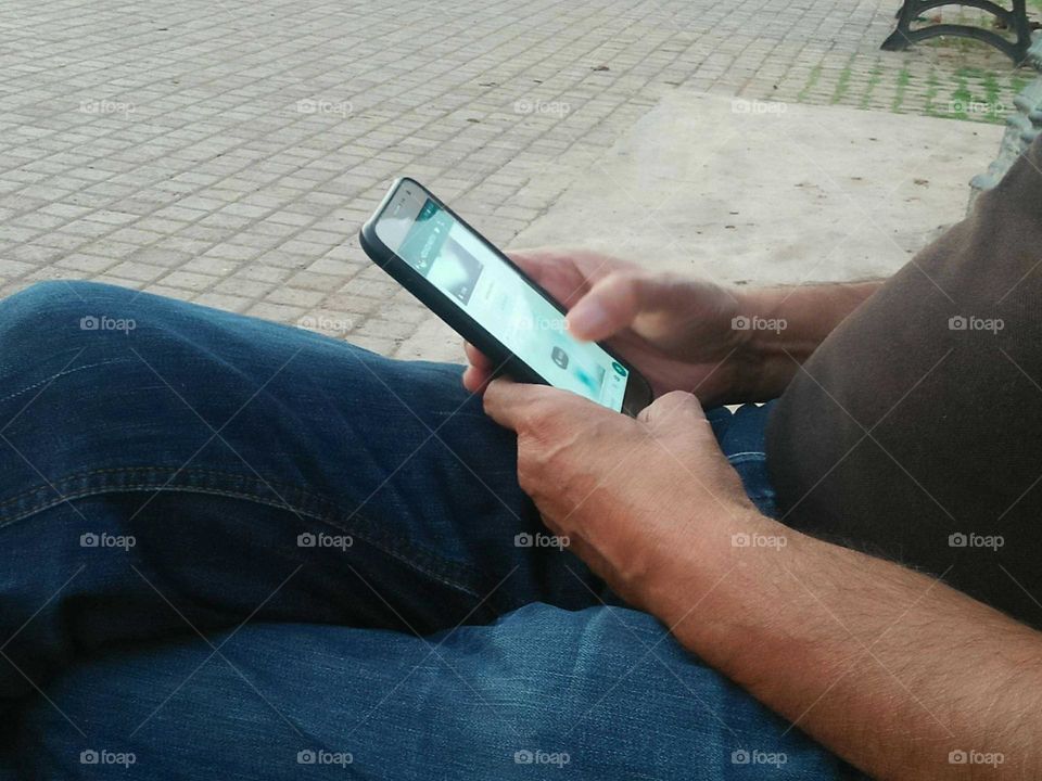 An adult man using its smartphone.