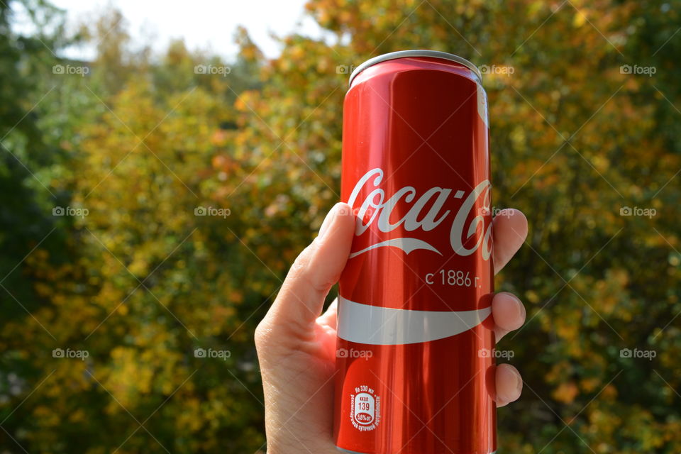 coca cola in hand, drinking coca cola outdoor