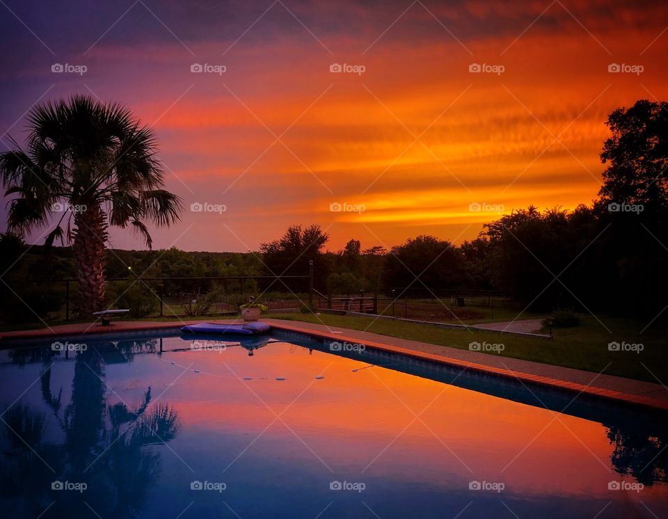 Serene brilliantly colored sunset with reflection in a pool