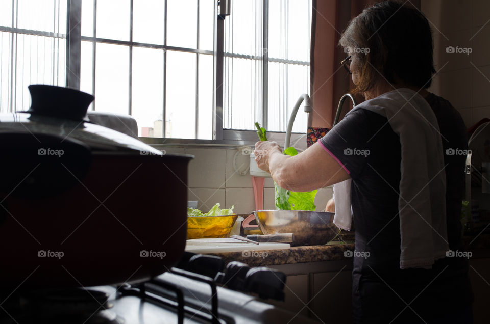 a woman sanitizing vegetables to make a delicious salad. A daily habit to take care of health.
