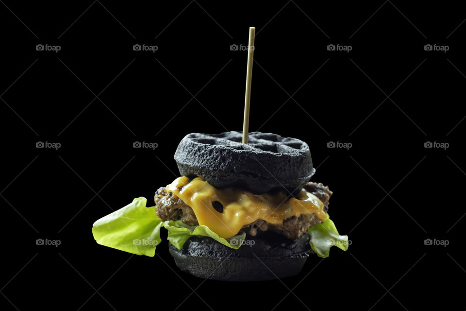 Isolated Hamburger black pork on a black background with clipping path.