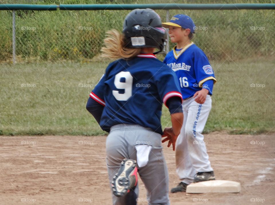 Girl Playing Baseball. Young Girl Running The Bases In American Little League Game
