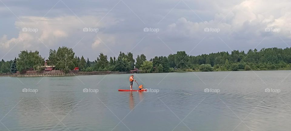 family father and son riding on a boat board on a lake summer time