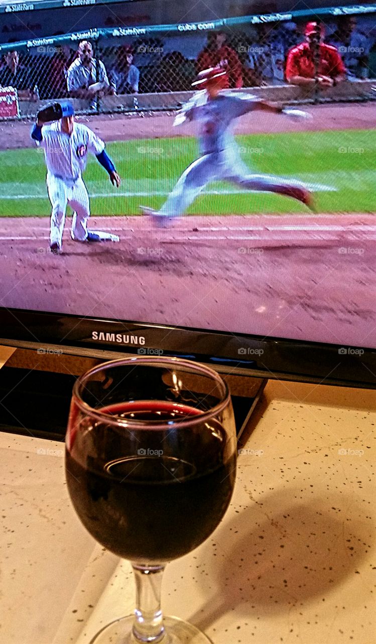 Watching the game with a glass of wine waiting for dinner to be ready.