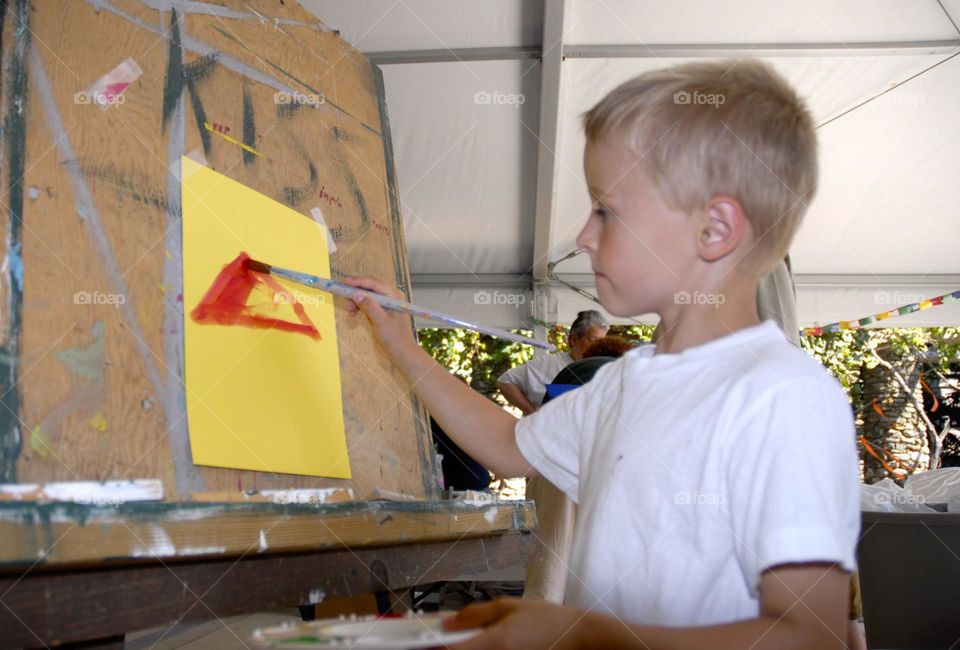 Creative kids, little boy, painting at easel