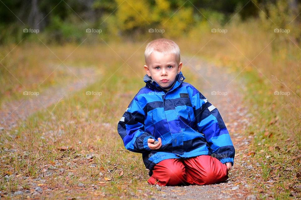 Boy sitting on a road 