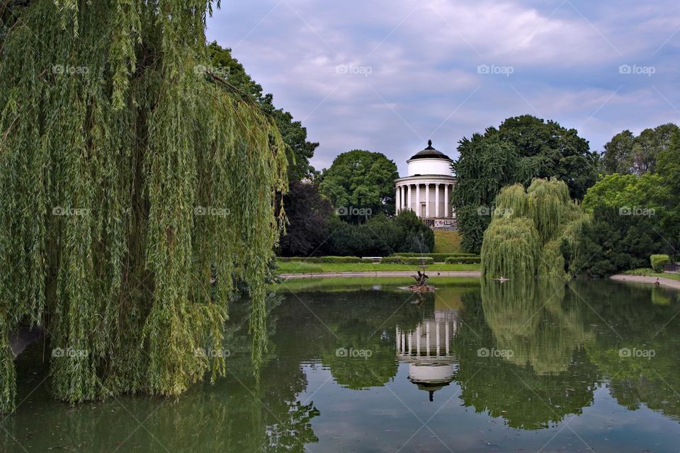 White building in the park is reflected in the pond