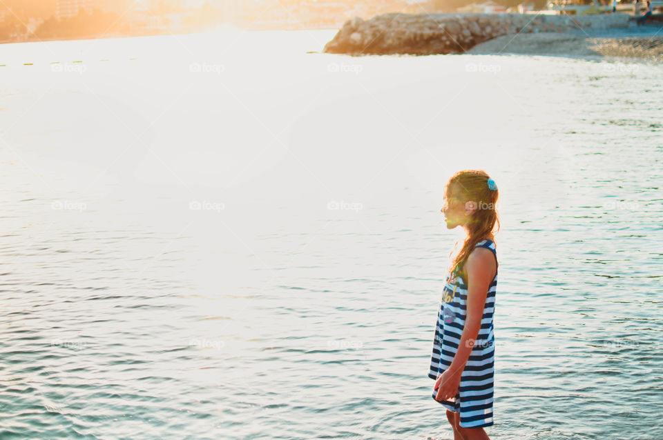 girl is walking on the sunset beach