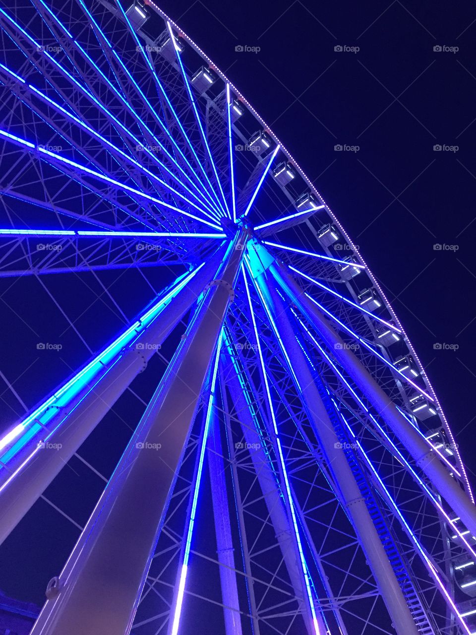 Ferris wheel with neon blue lights at night