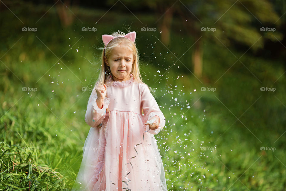 Cute little girl with blonde hair and confetti 