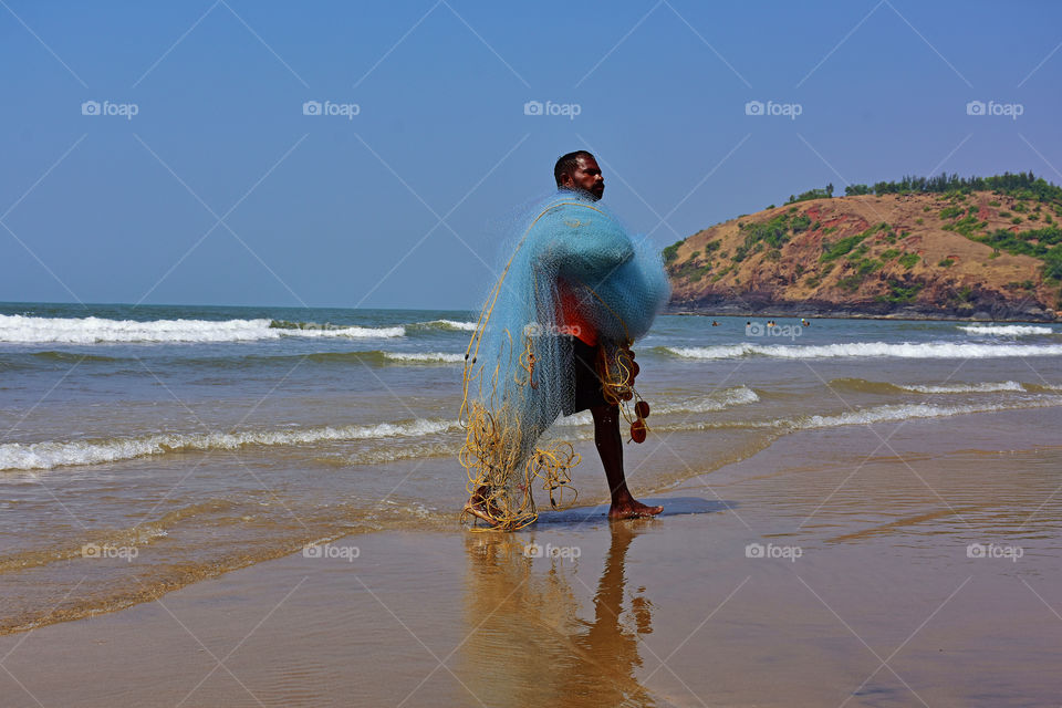 fisherman with fishing net in a beach