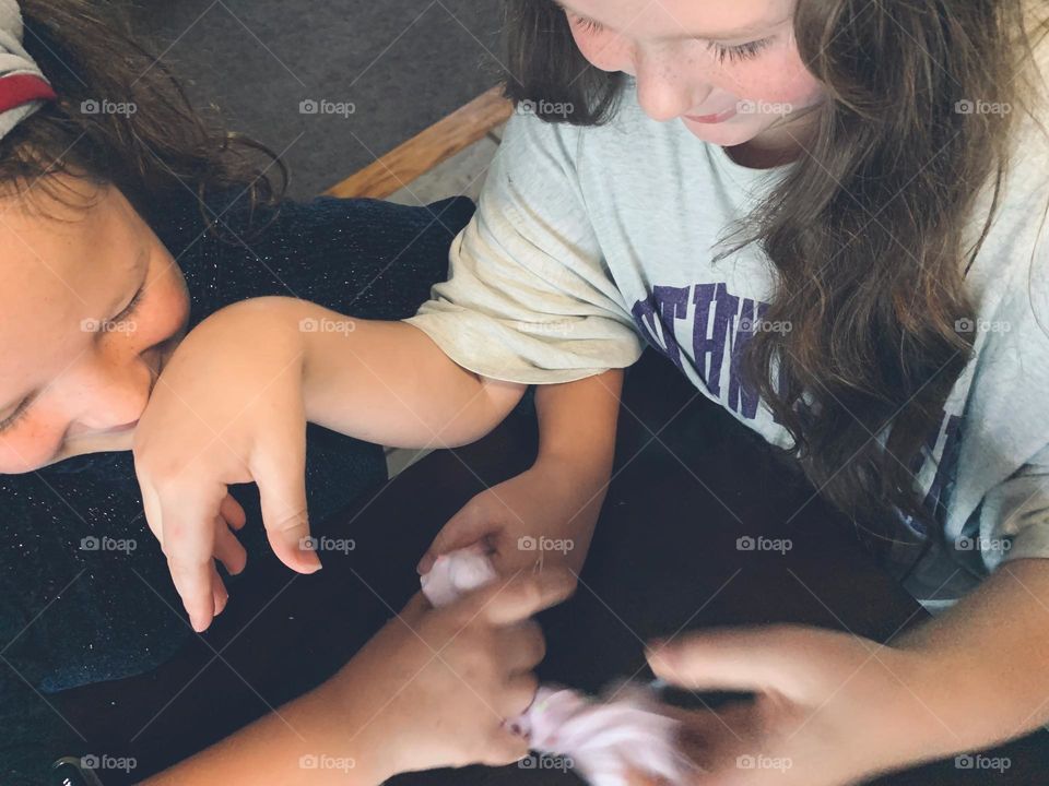 Glimmers Moment Of Happiness High Angle Of Children Sisters  Playing With Textured Pink Slime At The Table And Playing Around With Each Other.