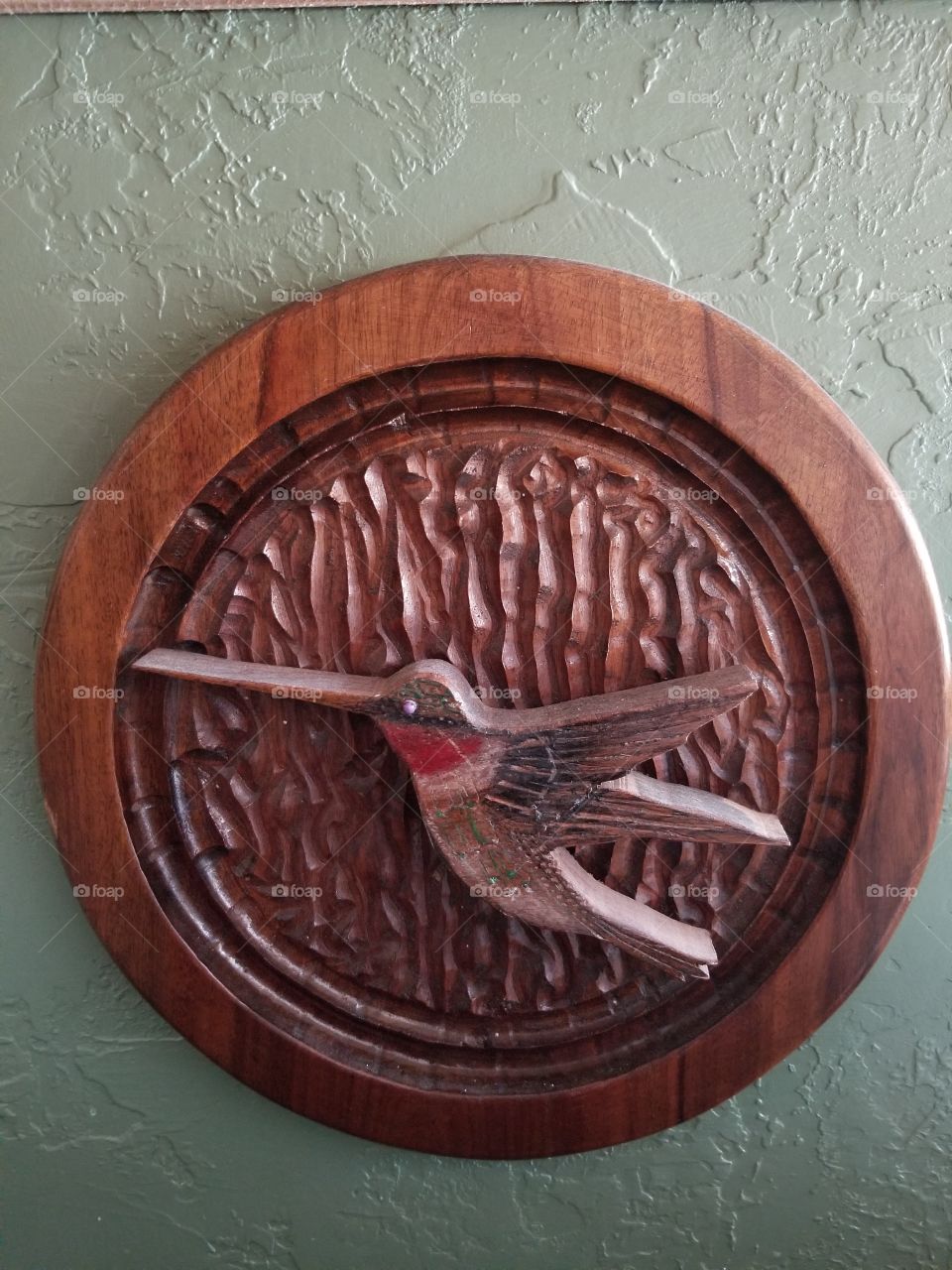 walnut hand carved hummingbird with a wavy background.  hand crafted,  beautiful artistry