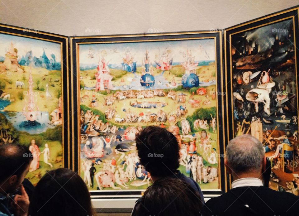 People looking at Garden of Earthly Delights in Prado Museum, Madrid