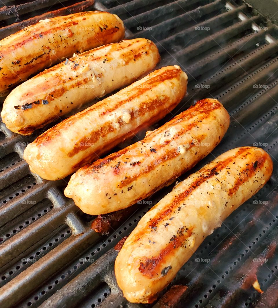 Delicious sausages slowly cook on a barbecue grill