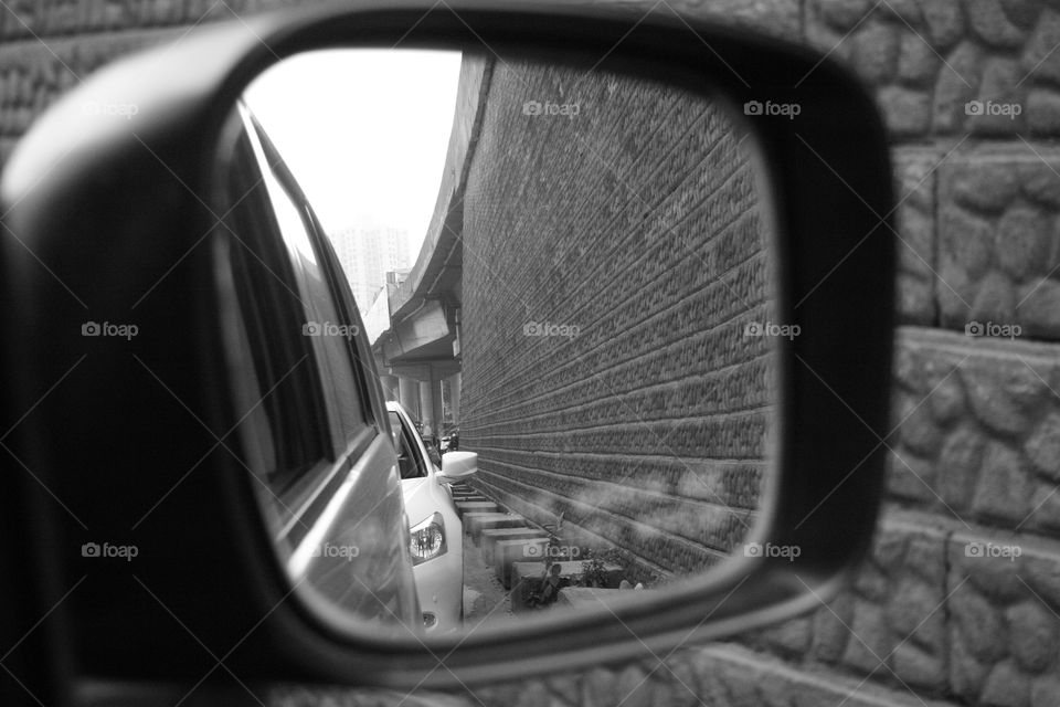A car mirror with reflection of wall in it