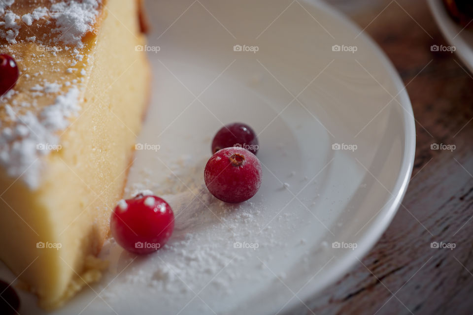 Cheesecake with cranberries and sugar on wooden background 