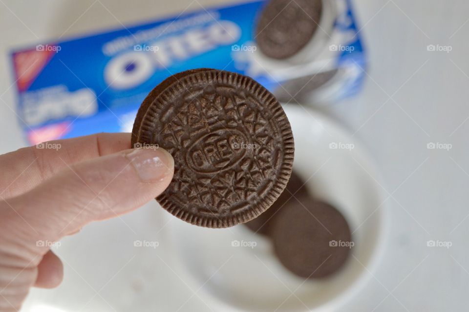 Woman’s hand taking a Oreo cookie from a plate