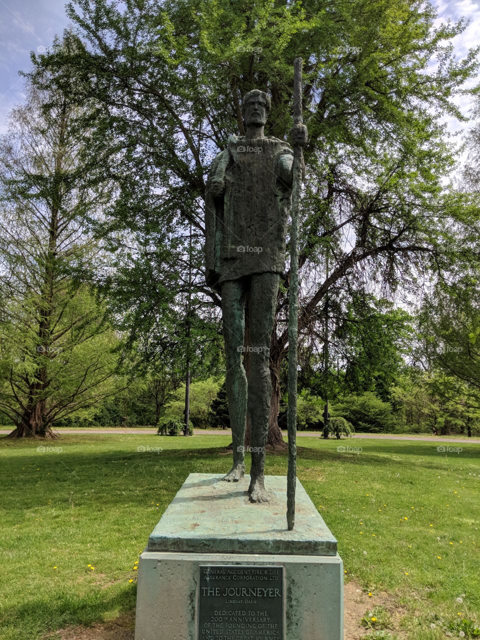 Journeyman statue in a green garden setting.
