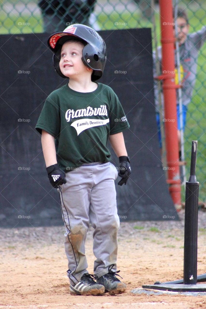 My little ball player scored his first run at his T-ball game, looking up proudly at his coach. 