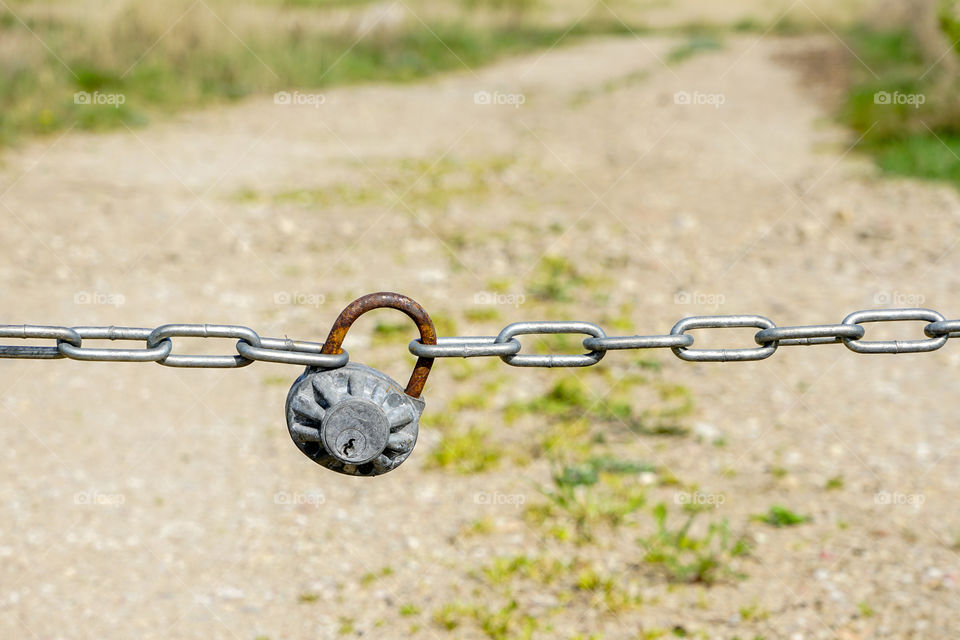 with chain and padlock closed gravelly country road