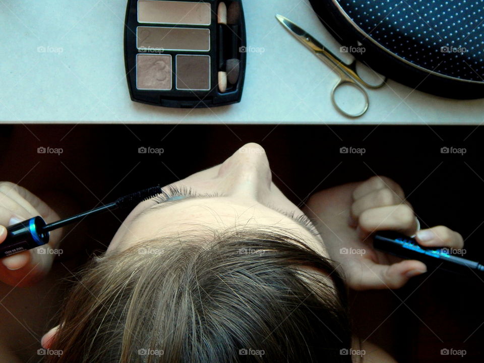 Young woman making make-up. View from above. Cosmetics to make-up.