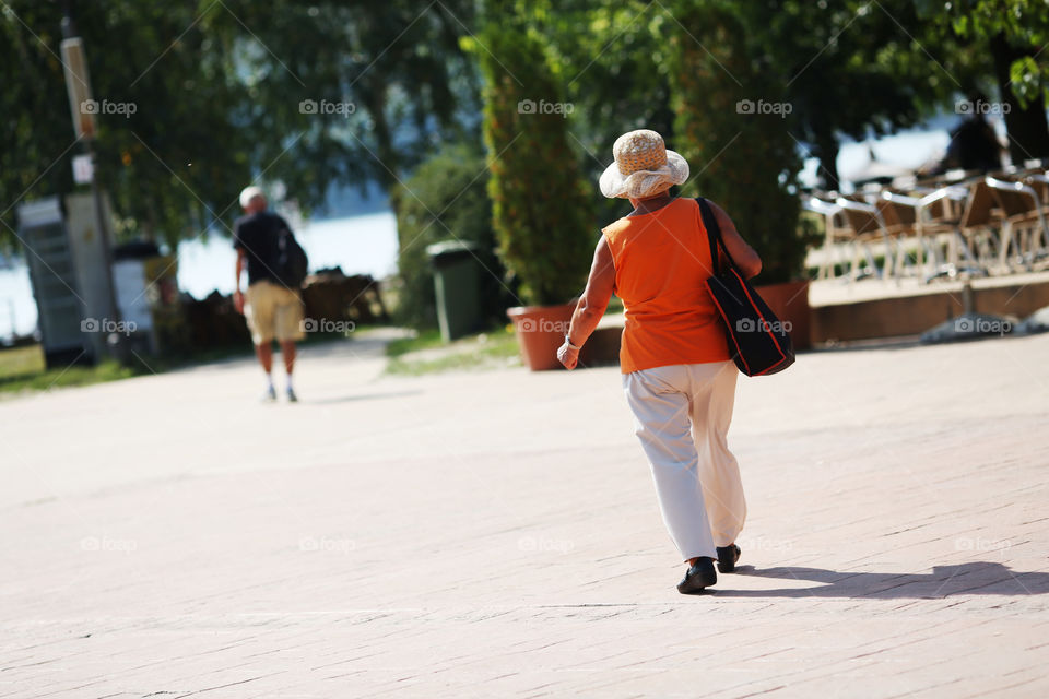 Elder lady with hat going to the beach