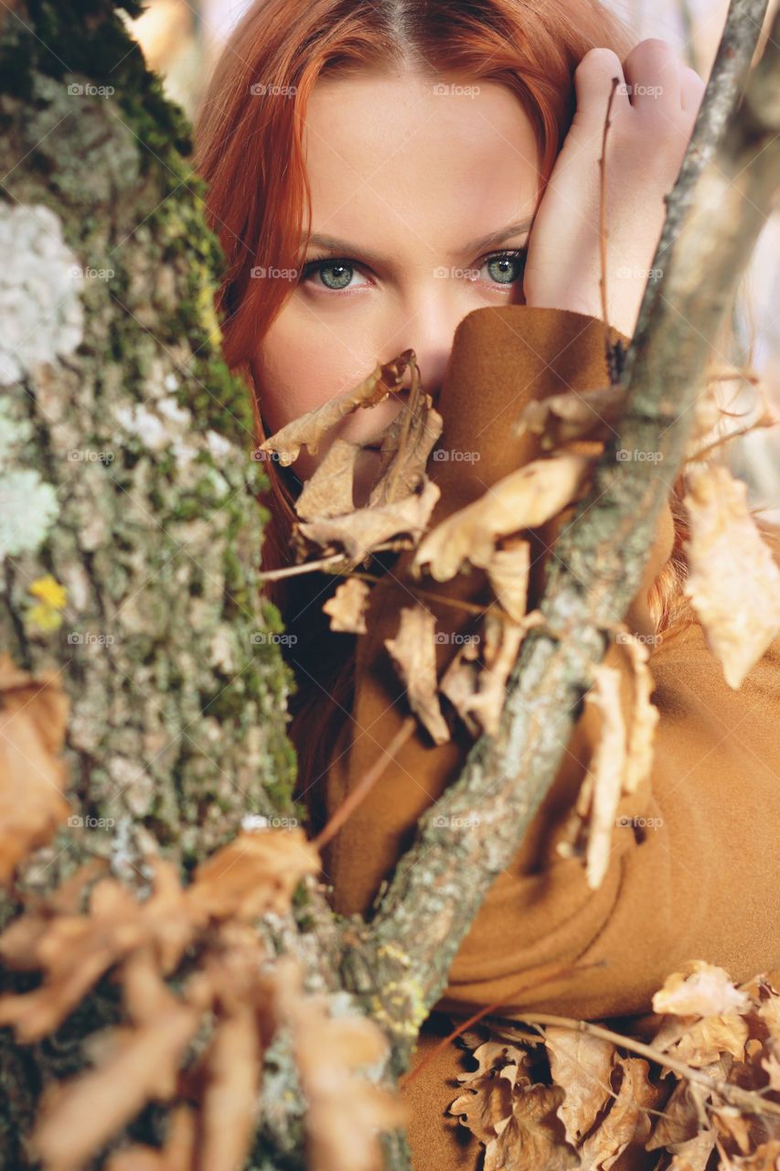 Pretty woman looking through dry tree