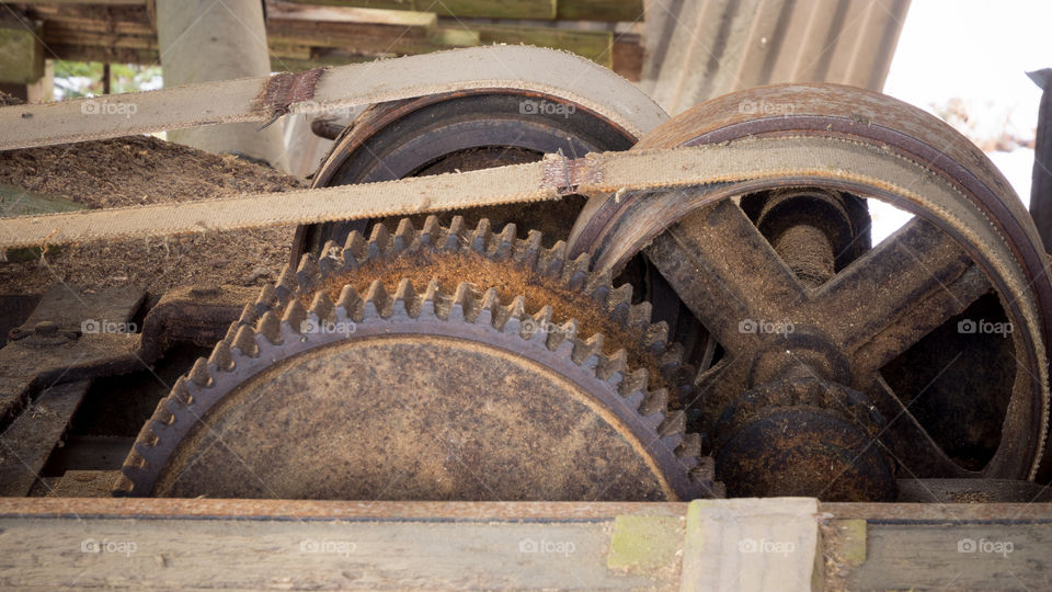the gears and belt drives of a run old sawmill that's seen better days. the roof is collapsing and it doesn't look like they've cut lumber for many years