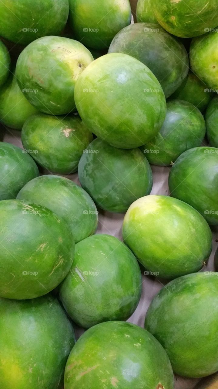 Watermelons, fresh harvest on display in a local market.