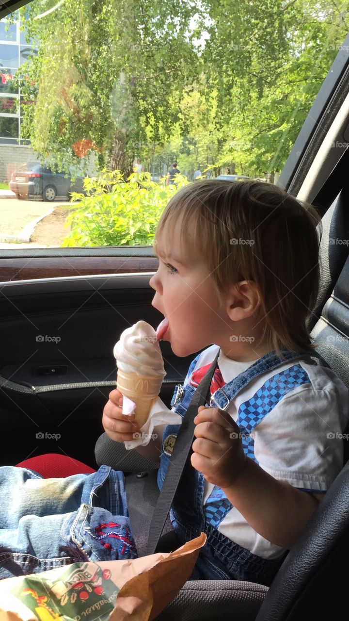 Little boy is eating an ice cream . Little boy is eating an ice cream in the car