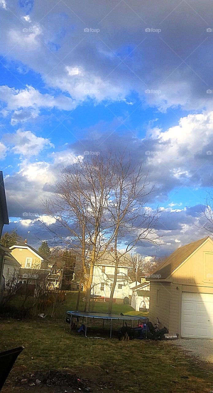 A beautiful bunch of cumulonimbus clouds in a brilliant bright blue sky in a backyard in Ohio