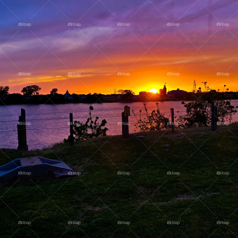 Sunset over the Arkansas River in Oklahoma turns the sky a brilliant purple and orange