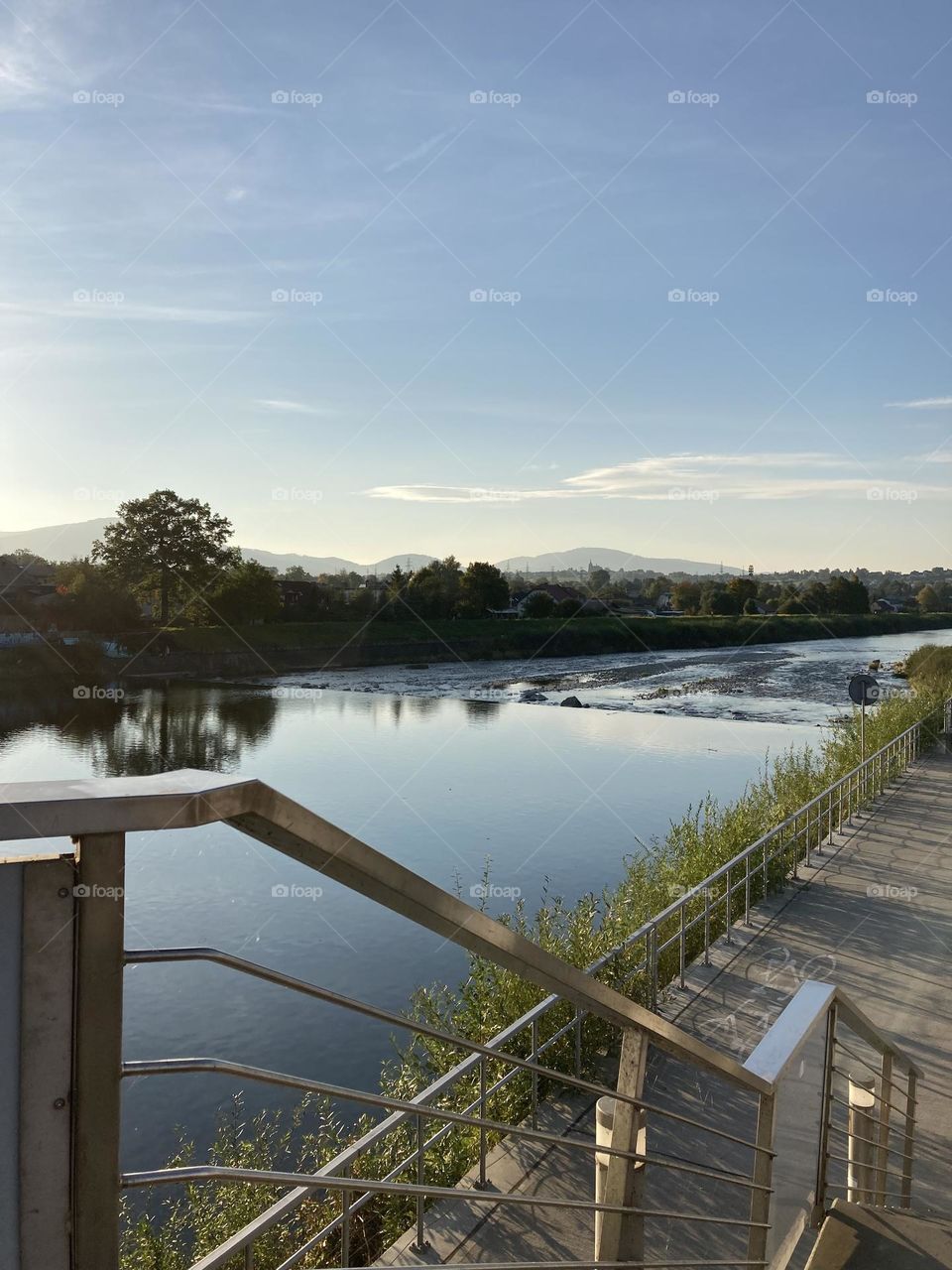 Sunny day by the lake litre trips in Europe Poland. Beautiful blue sky and water, little wooden bridge by the shore. 