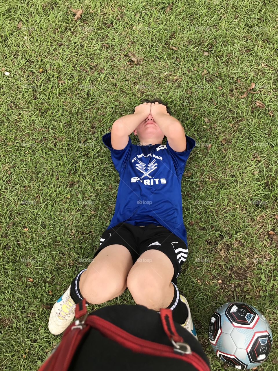 This cute teen boy is whooped after his grueling soccer game on a hot day!