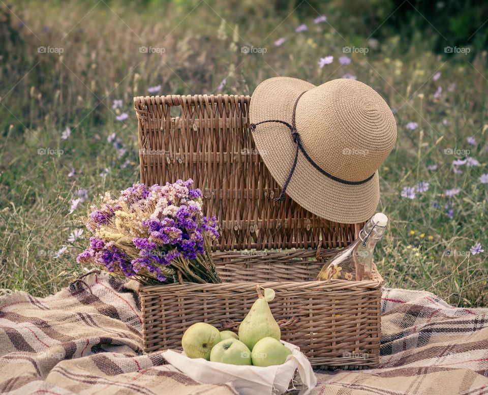 Vintage picnic hamper with sun hat, fruit & dried flowers