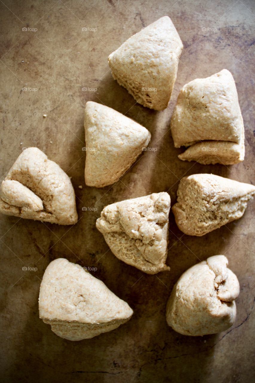 Overhead view of sourdough spelt and whole wheat dough for bagels on baking stone, proportioned for rolling and shaping